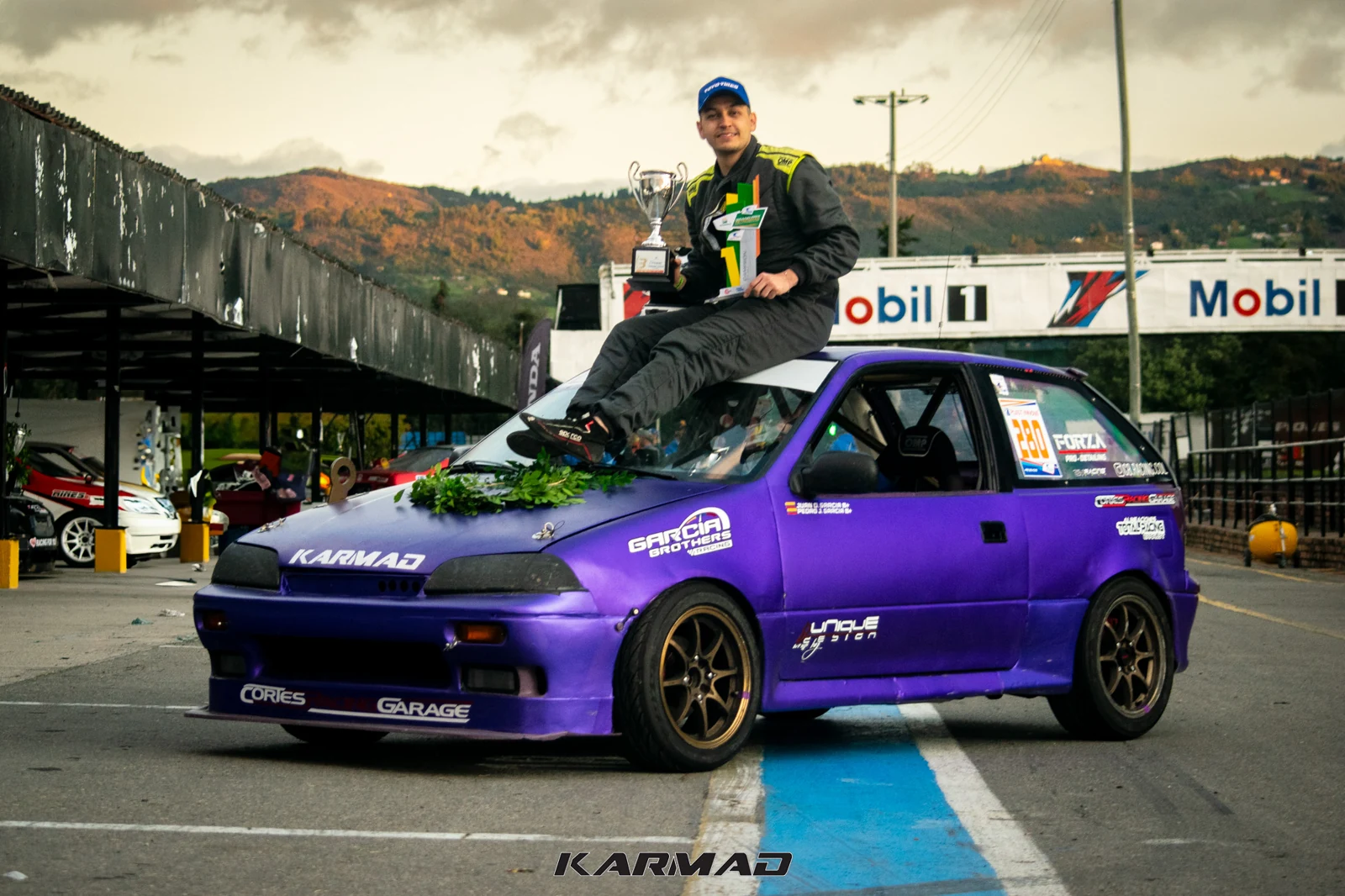 El piloto celebra solo sobre el Swift morado con los trofeos de la última fecha de 2024